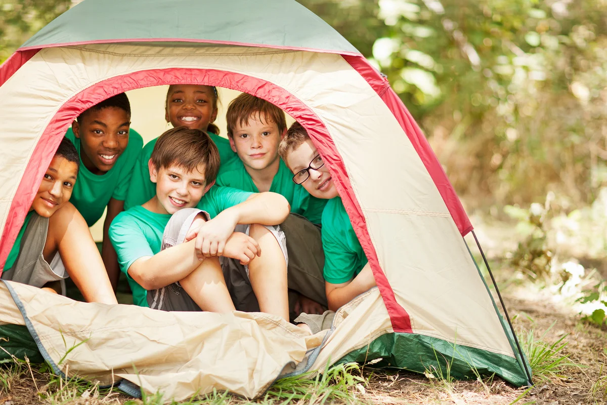Students sitting in camp tent