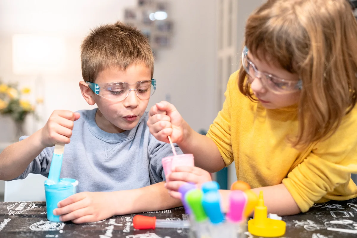 Girl with brother making slime at home