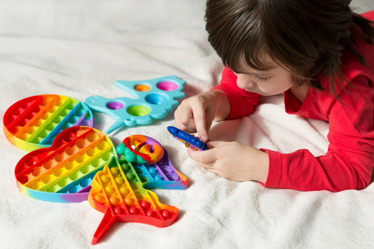 Kid plays with push pop fidget toy