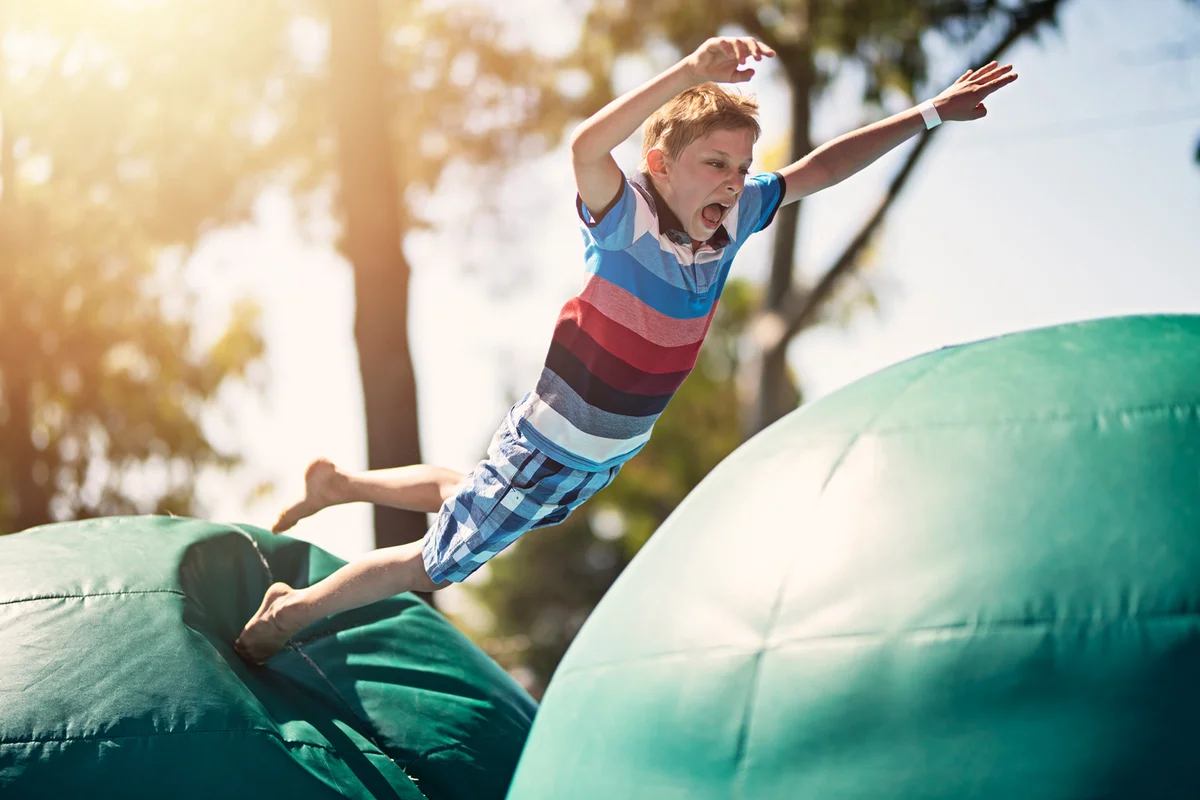 boy having fun on inflatable obstacle