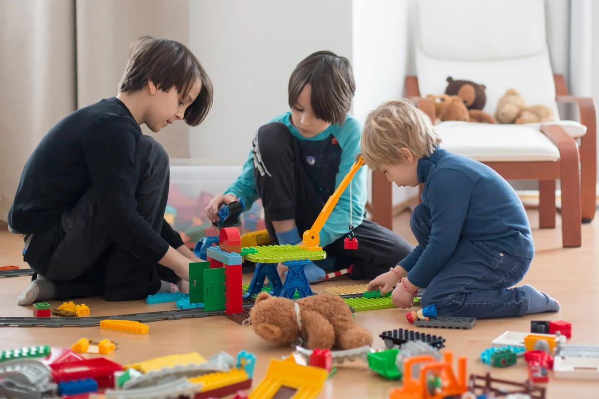 Little boys building house of block toys sitting on the floor
