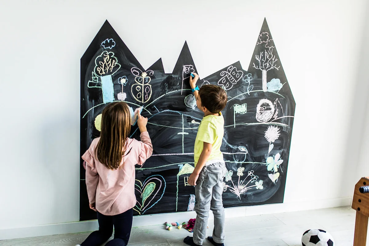 Brother and sister drawing on the blackboard