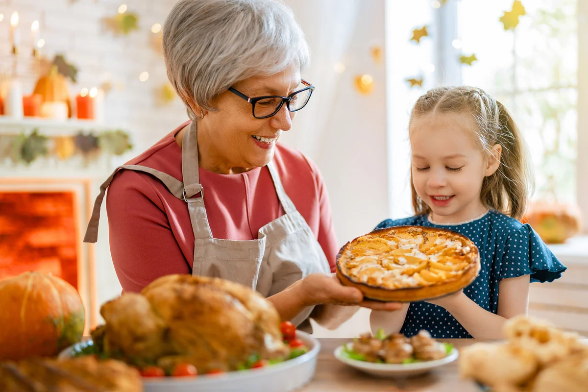 grandmother and granddaughter with Thanksgiving dessert in kitchen