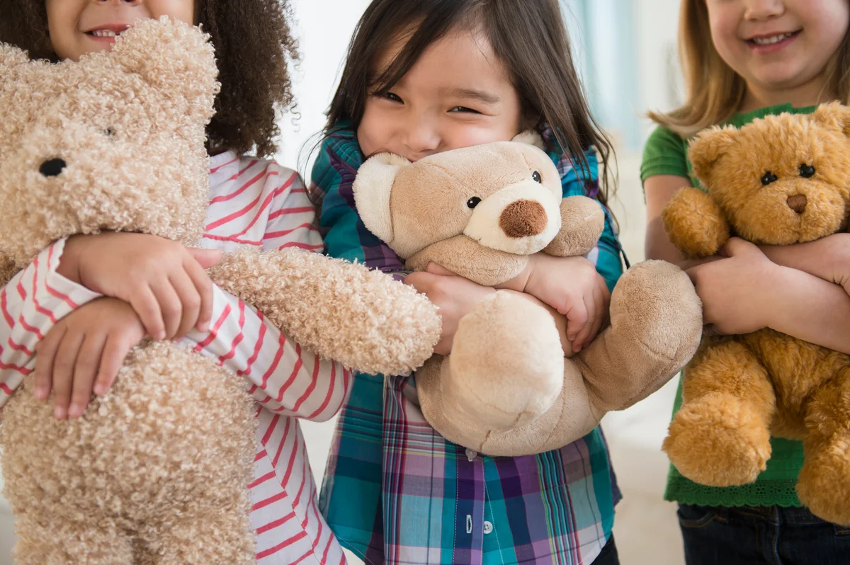 girls at sleepover party hugging stuffed toys
