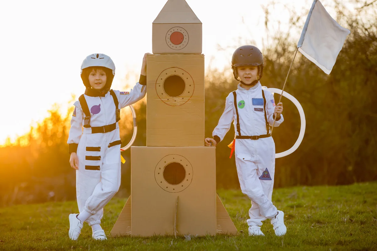 Two children playing dressed like astronauts