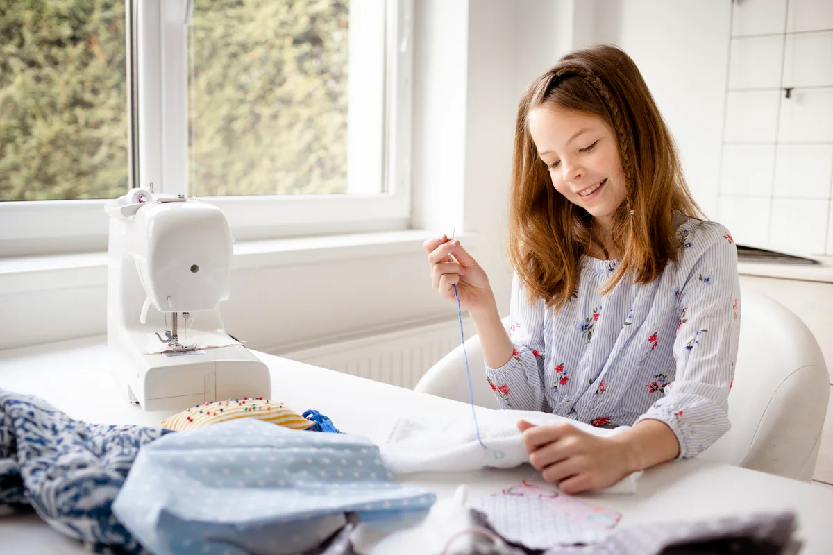 Girl sewing in a room with natural light
