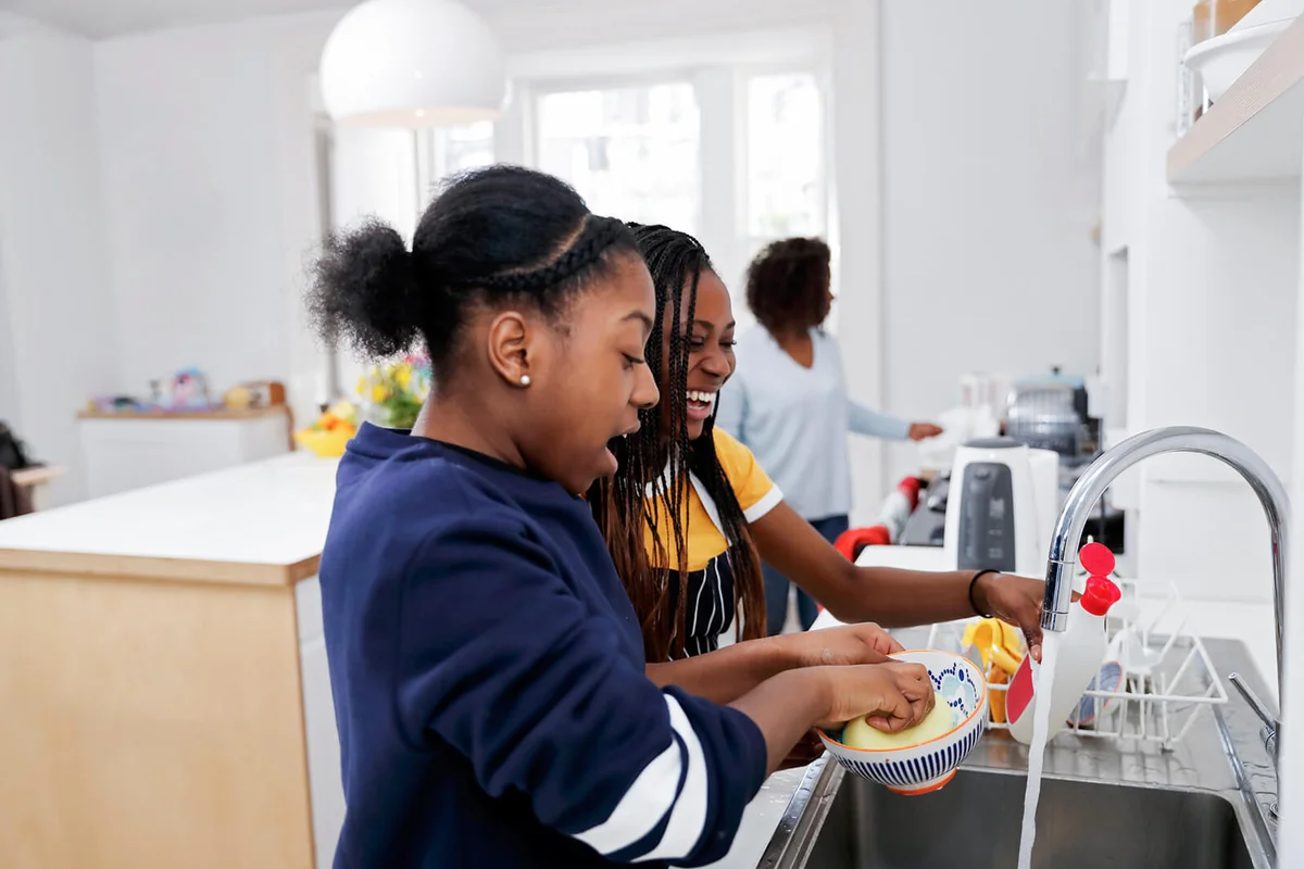 Two teenage girls washing dishes