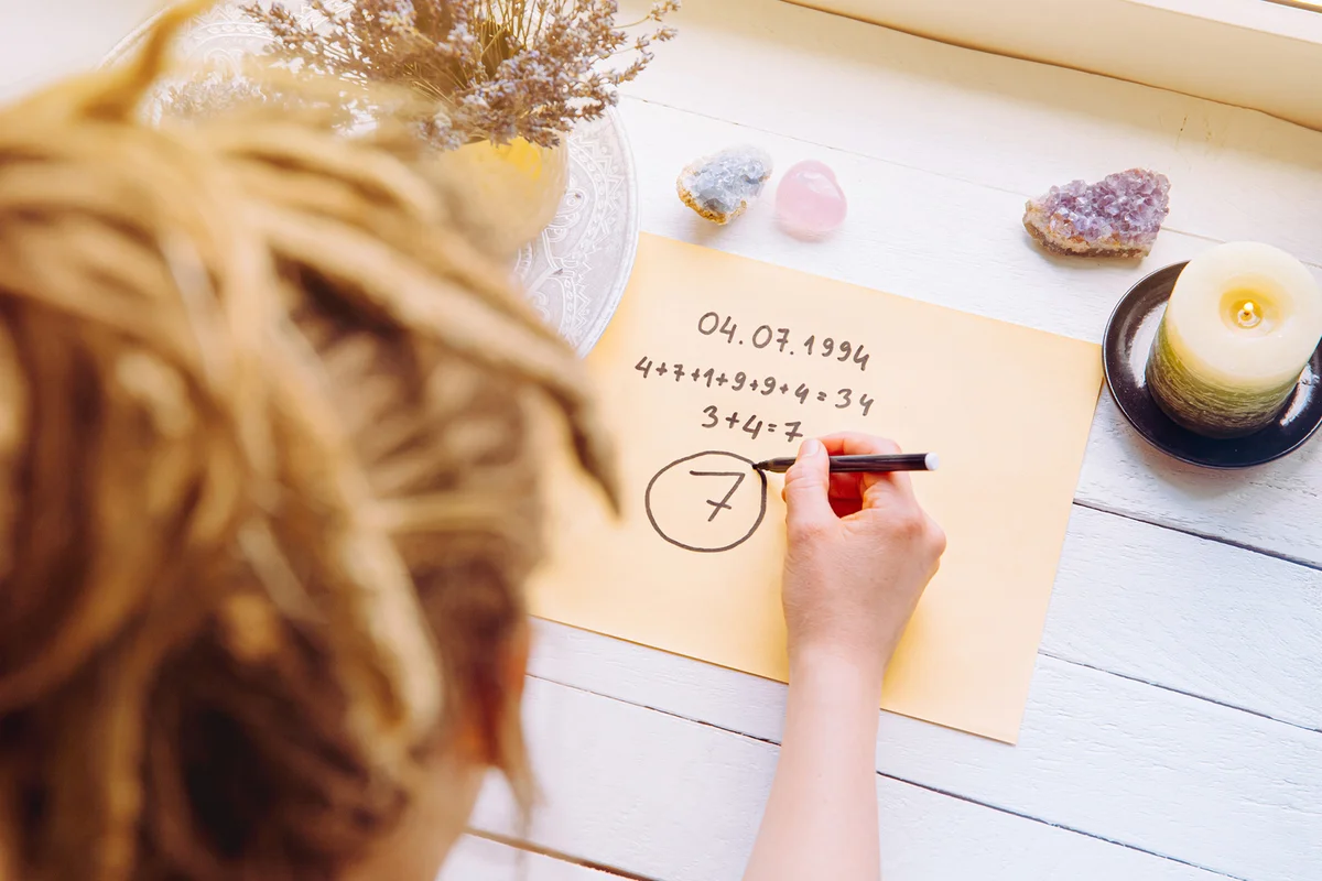Girl calculate Life path number on paper in home