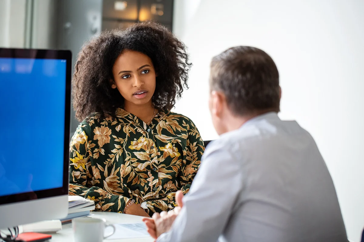 Woman having meeting with male colleague on office