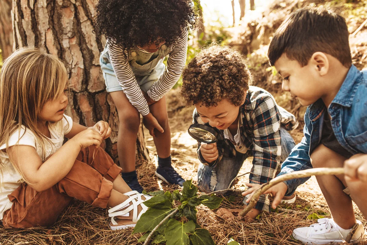 Kids in forest with a magnifying glass