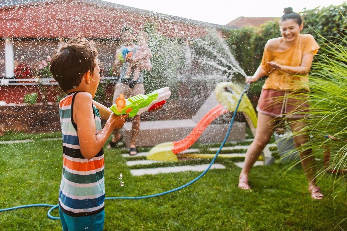 family squirt water gun fight in yard