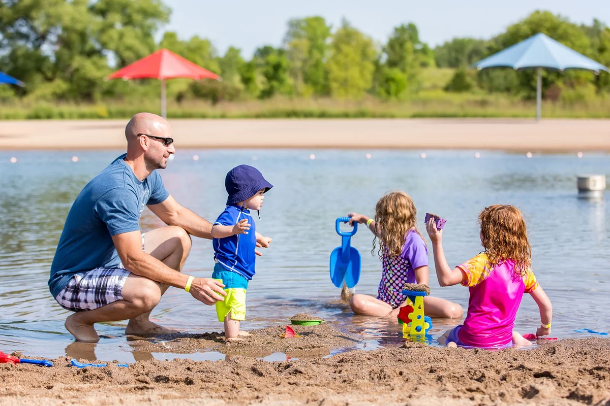 family playing on beach at lake