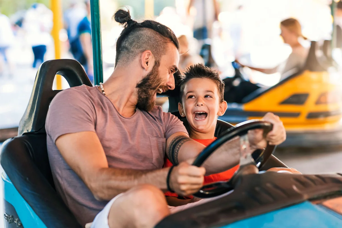 father and son in bumper car at fairgrounds