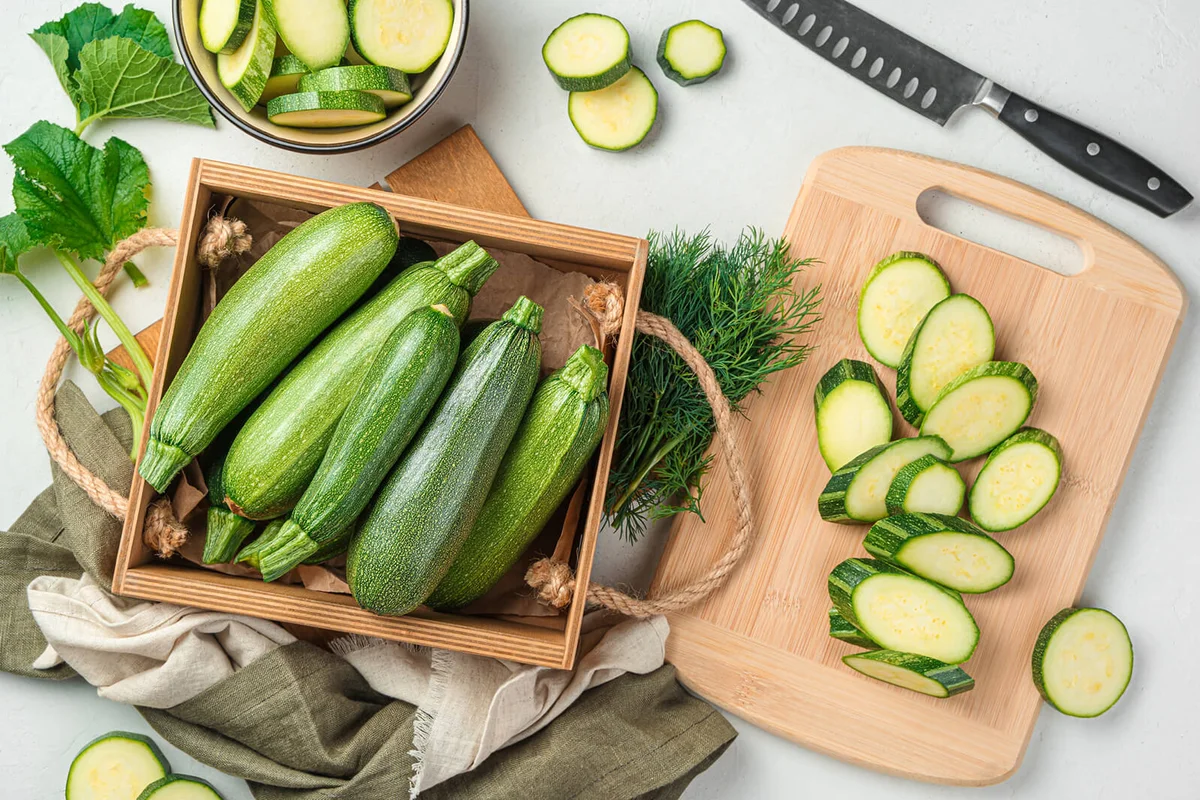 Slicing zucchini on a cutting board.