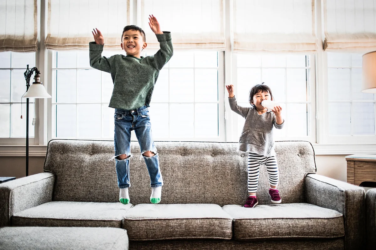 kids jumping on couch at home
