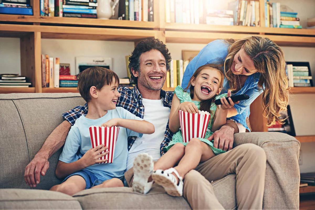 happy family watching movies on the sofa at home