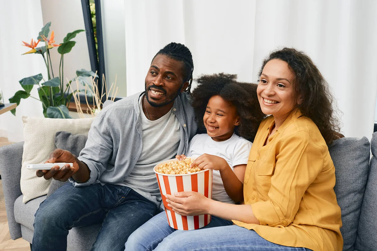 Fun family with little daughter are watching comedy movie together
