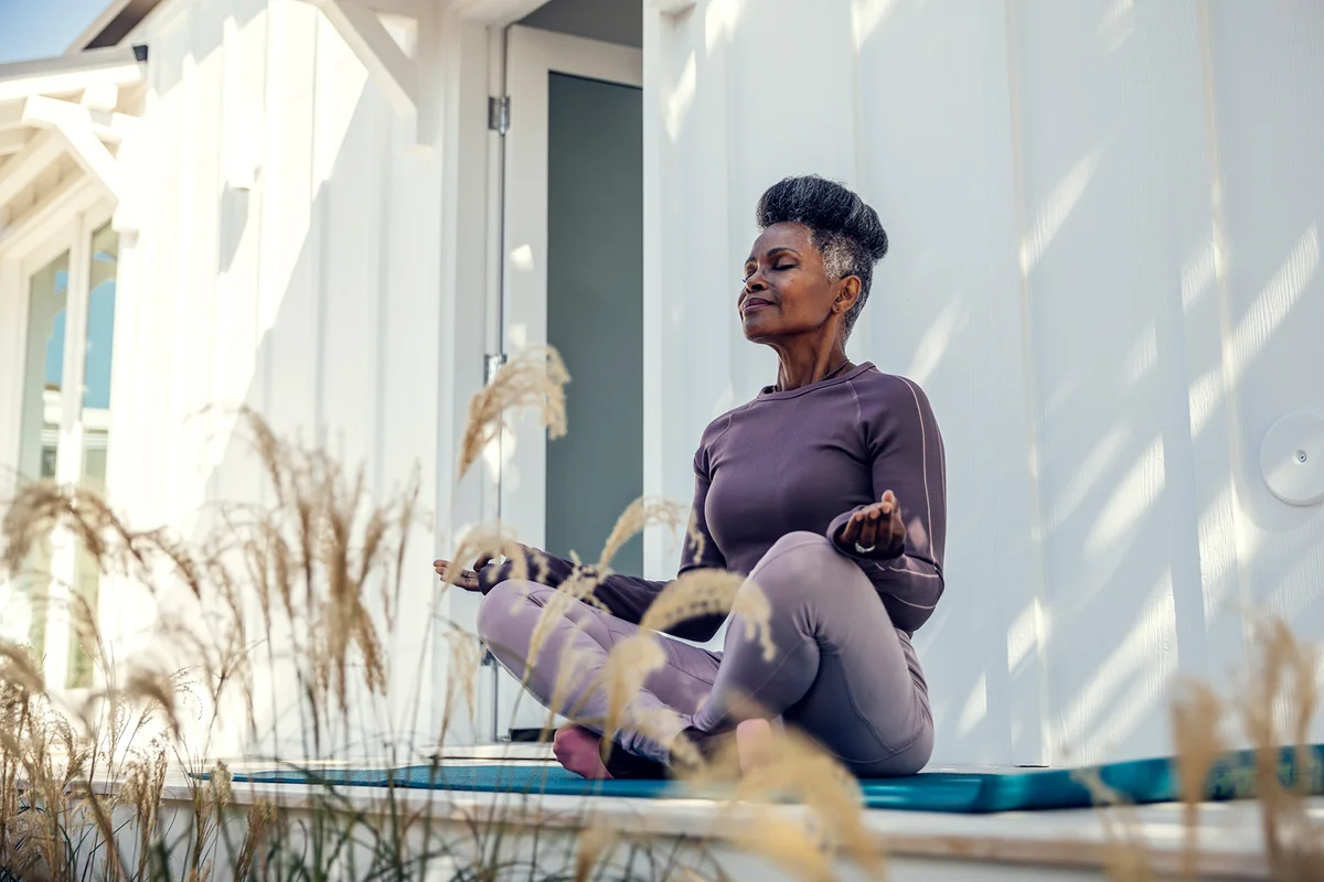 Mature woman meditating in backyard