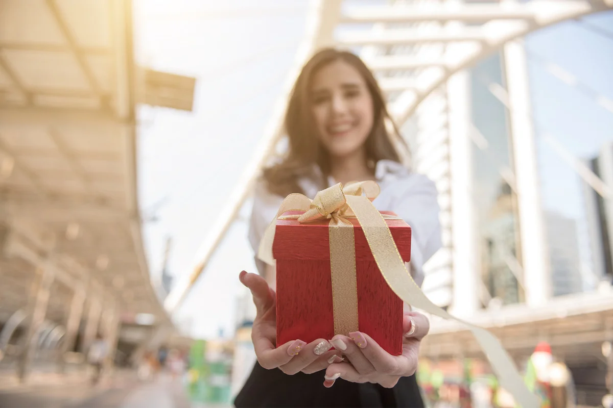Woman holding small gift with ribbon