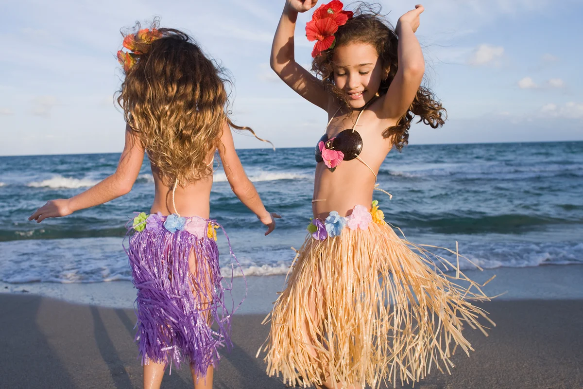 girls dancing in hula skirts on beach