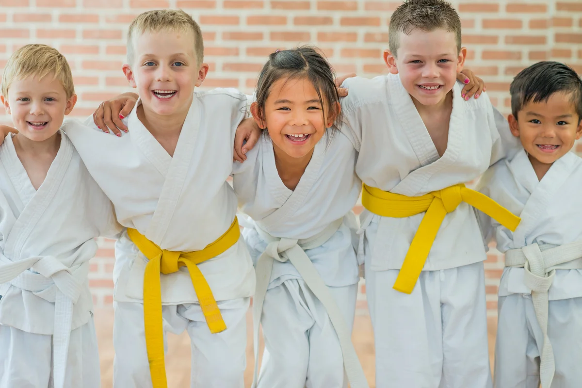 A group of elementary age children are taking a martial arts class
