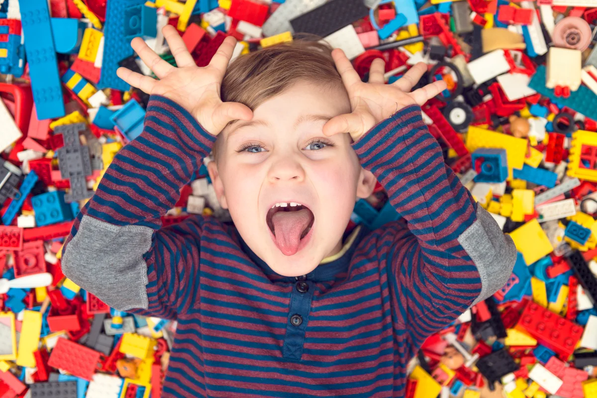 Playful boy between Lego pieces