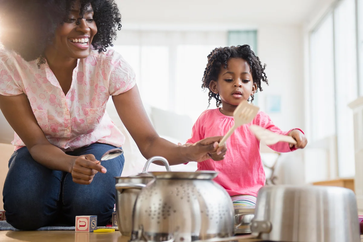 Mother and daughter playing music with pots and pans