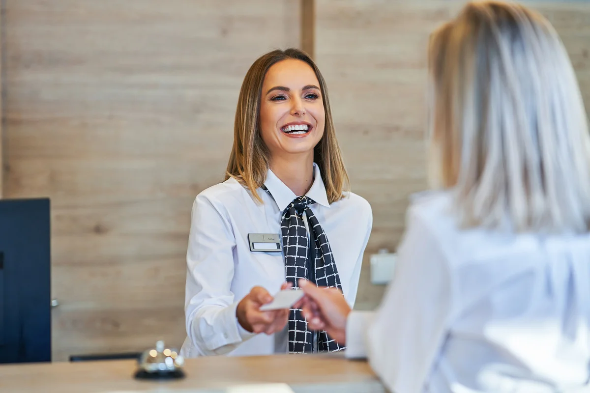 Receptionist and businesswoman at hotel front desk