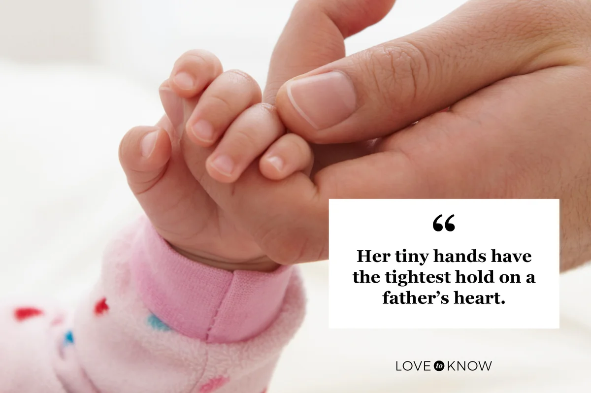 father holding infant daughter's hand