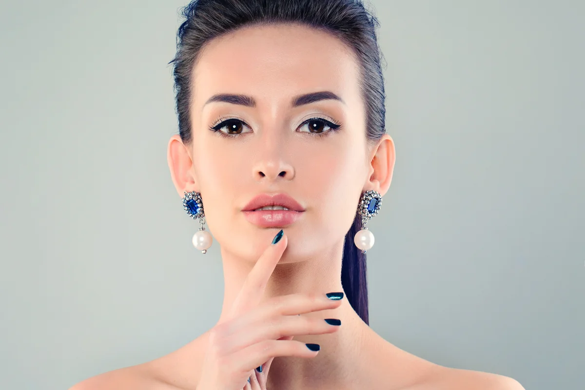 Woman wearing silver earrings with pearls and Sapphire