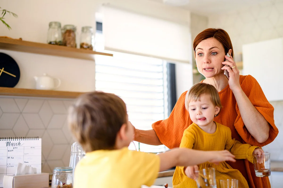 stressed out mother in kitchen with children