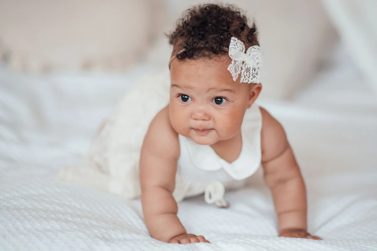 infant girl with white lace bow in hair