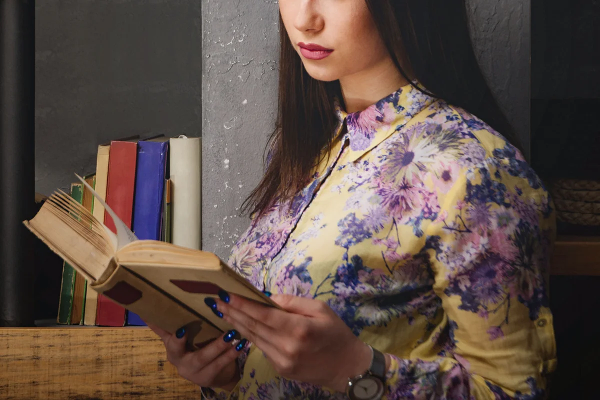 woman reading antique book in dark room