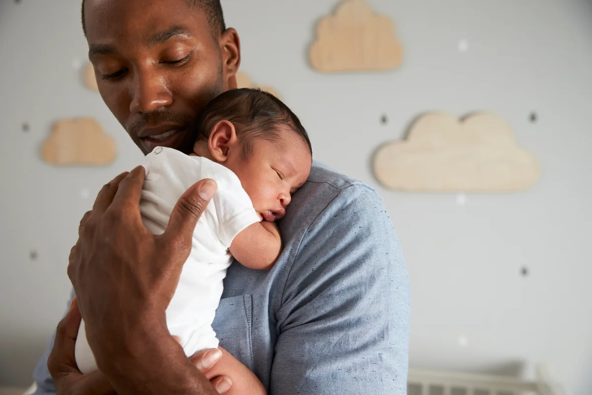 father holding sleeping infant