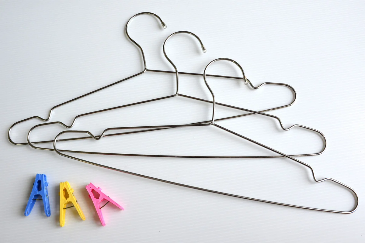 metal hanger and clothes pins to organize sewing fabric