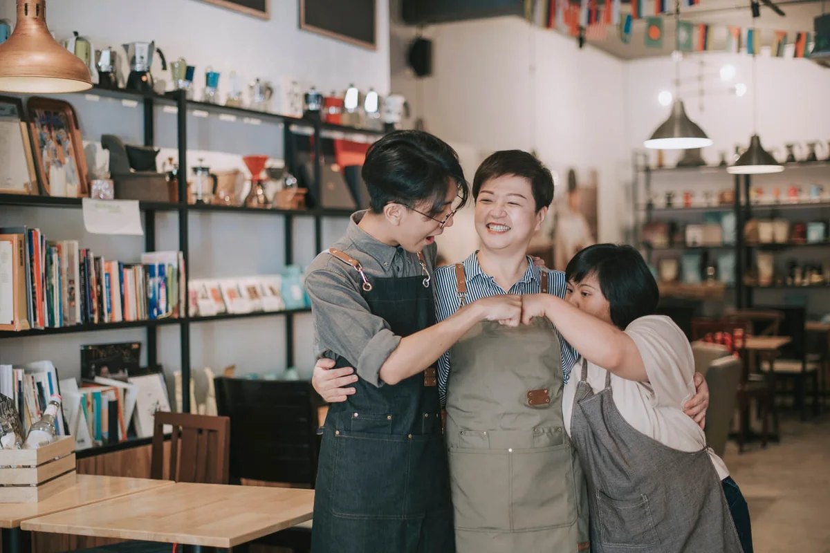 employee and owner fist bump bonding time in cafe happily