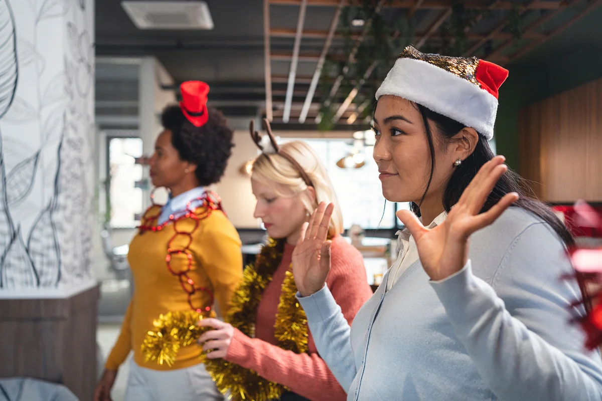 Modern and serene multiracial businesswomen dancing during Christmas office party