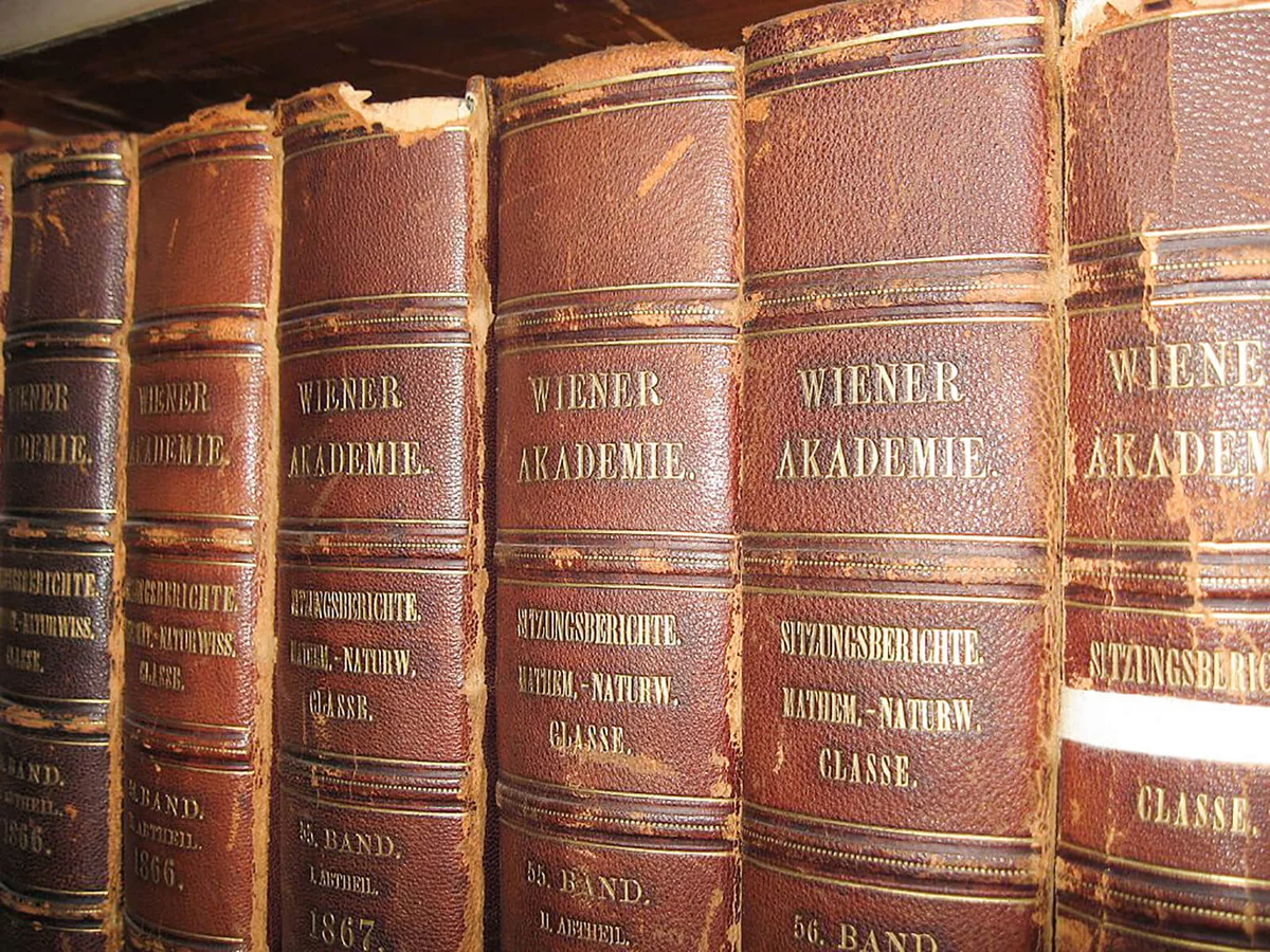 Multiple worn, leather bound books in a row on a bookshelf in a special collection library | Getty Editorial Use