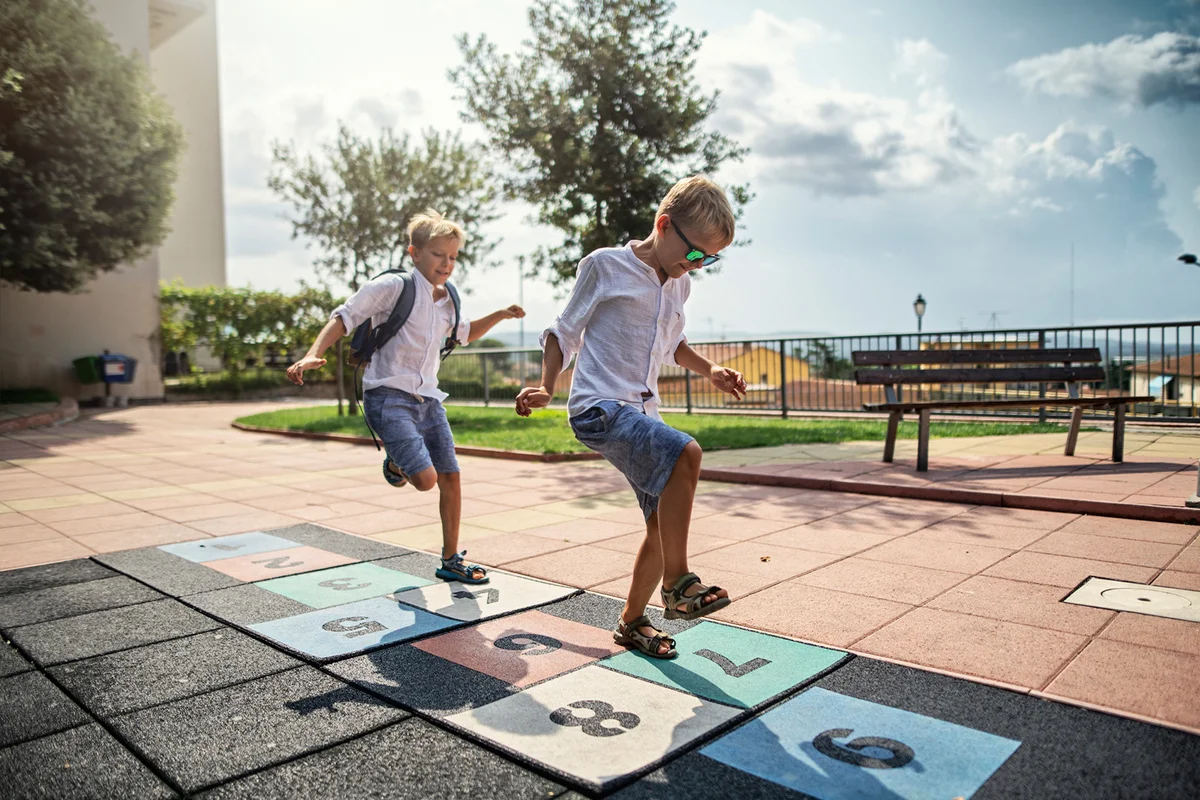 Little boys playing in hopscotch schoolyard