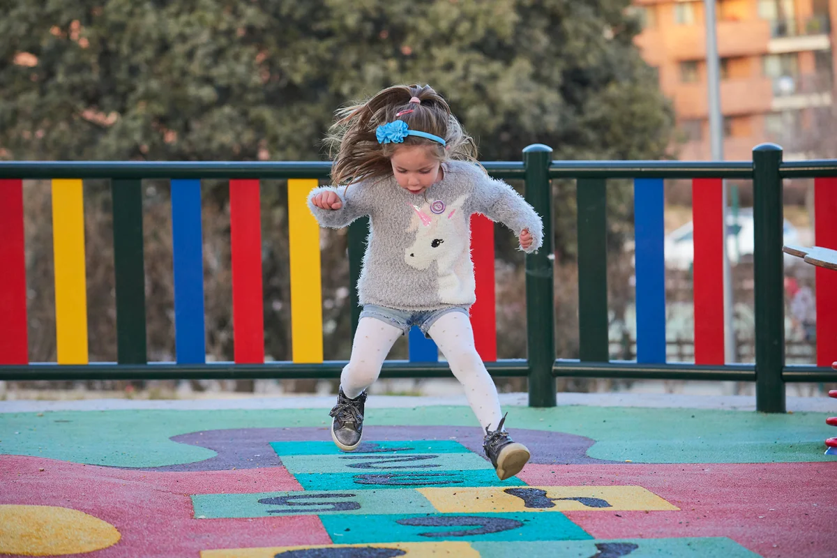 Girl playing hopscotch in the playground