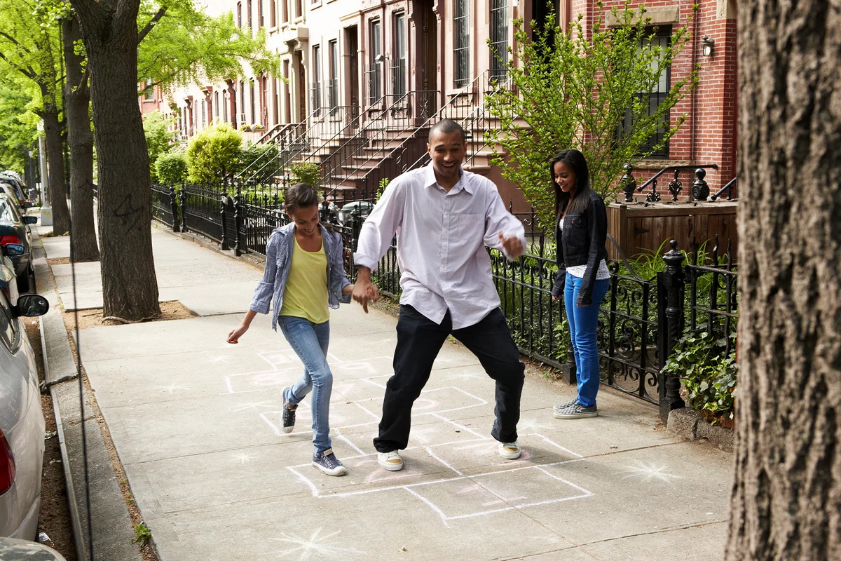Father & daughters playing hopscotch