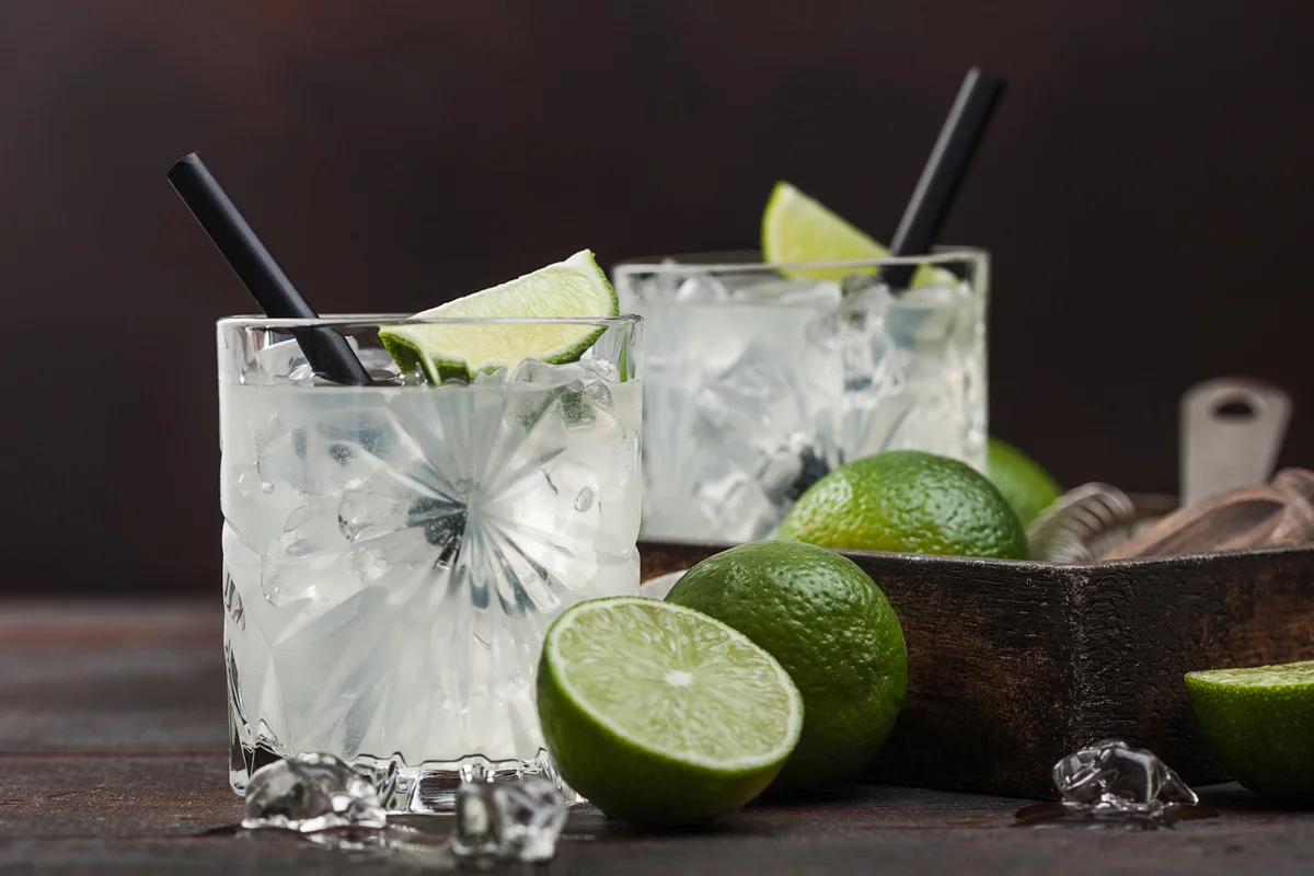 Gimlet Kamikaze cocktail in crystal glasses with lime slice and ice