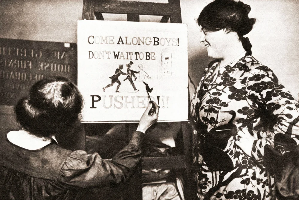 A young girl during World War One painting a recruitment poster