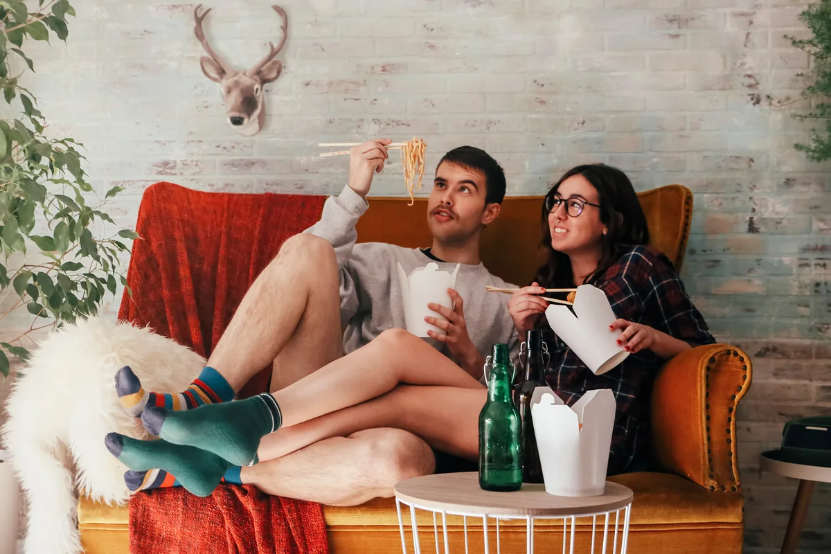 Young couple eating chinese take-away food at home