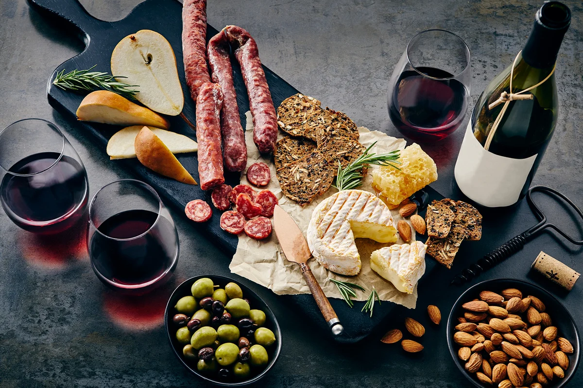 Wine charcuterie and cheese platter with pears nuts and olives