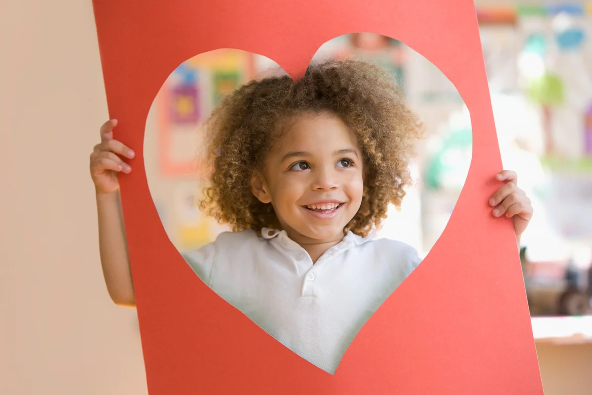 Boy looking through heart-shaped hole