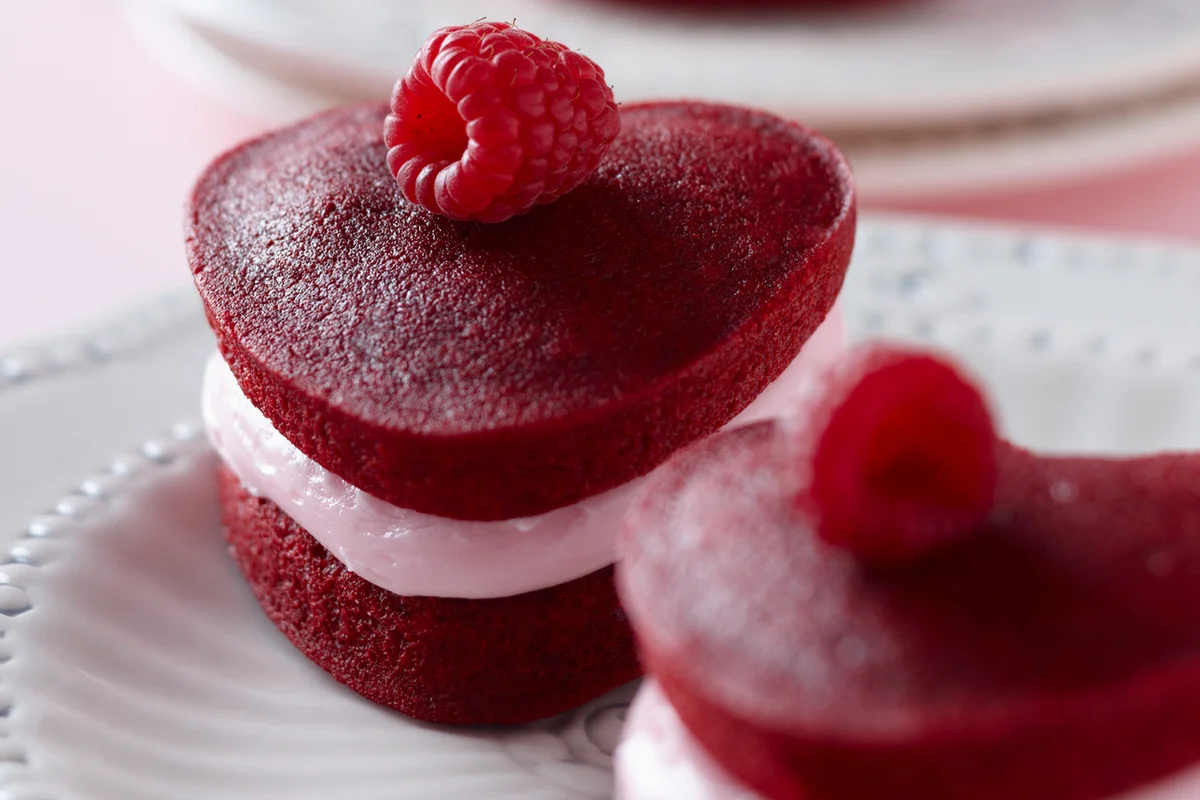 Heart shaped red velvet whoopie pies on plate