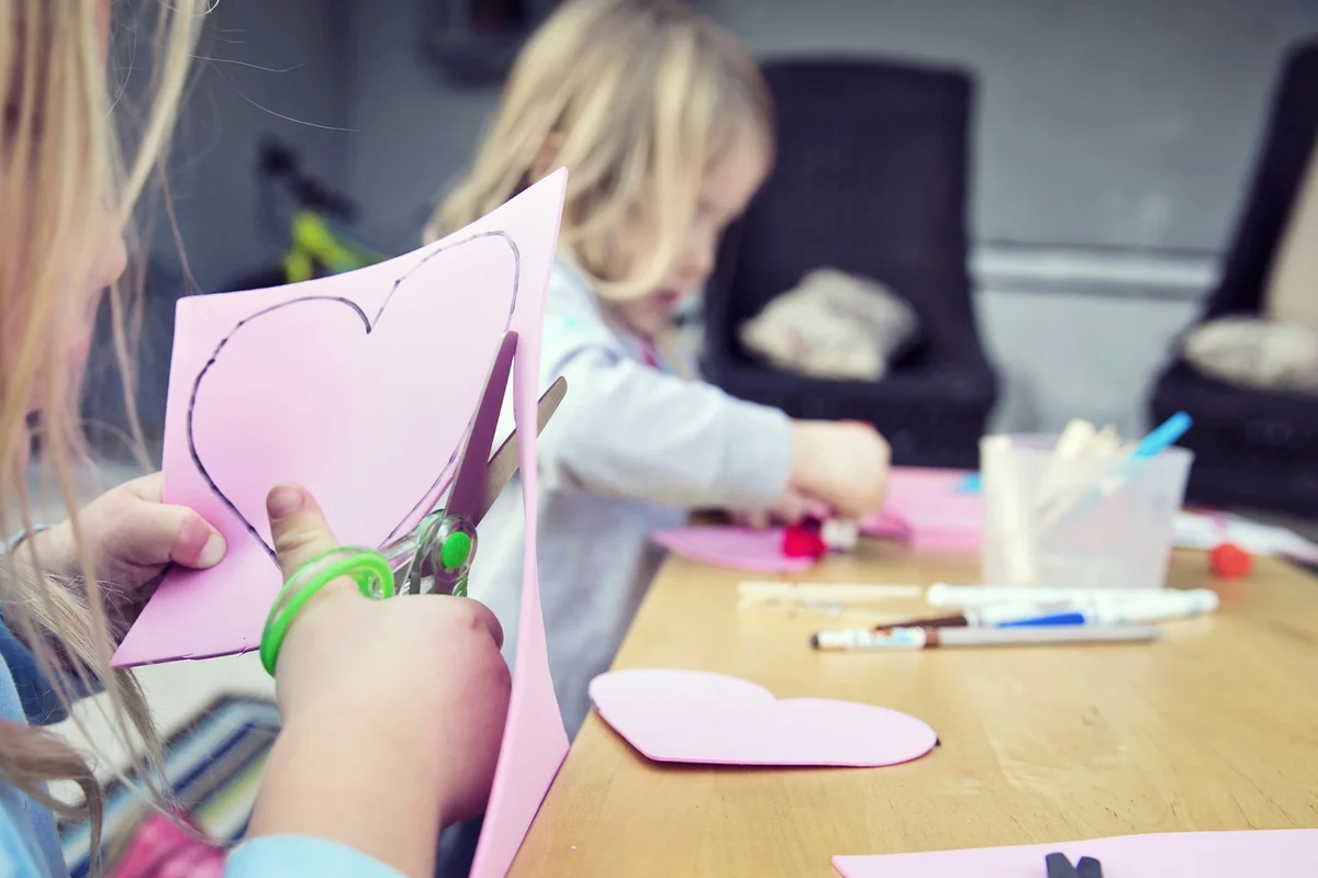 Girls cuts out a paper heart