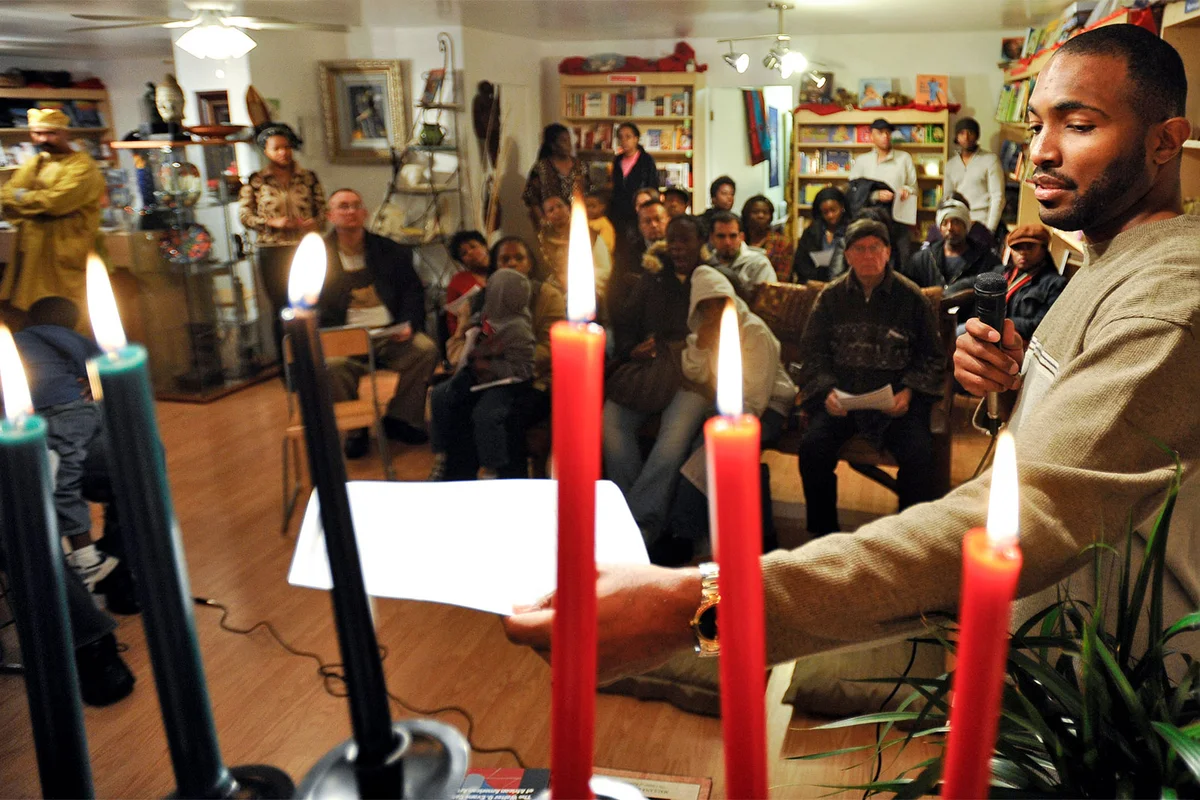 man discusses the meaning of the candles during a Kwanzaa celebration
