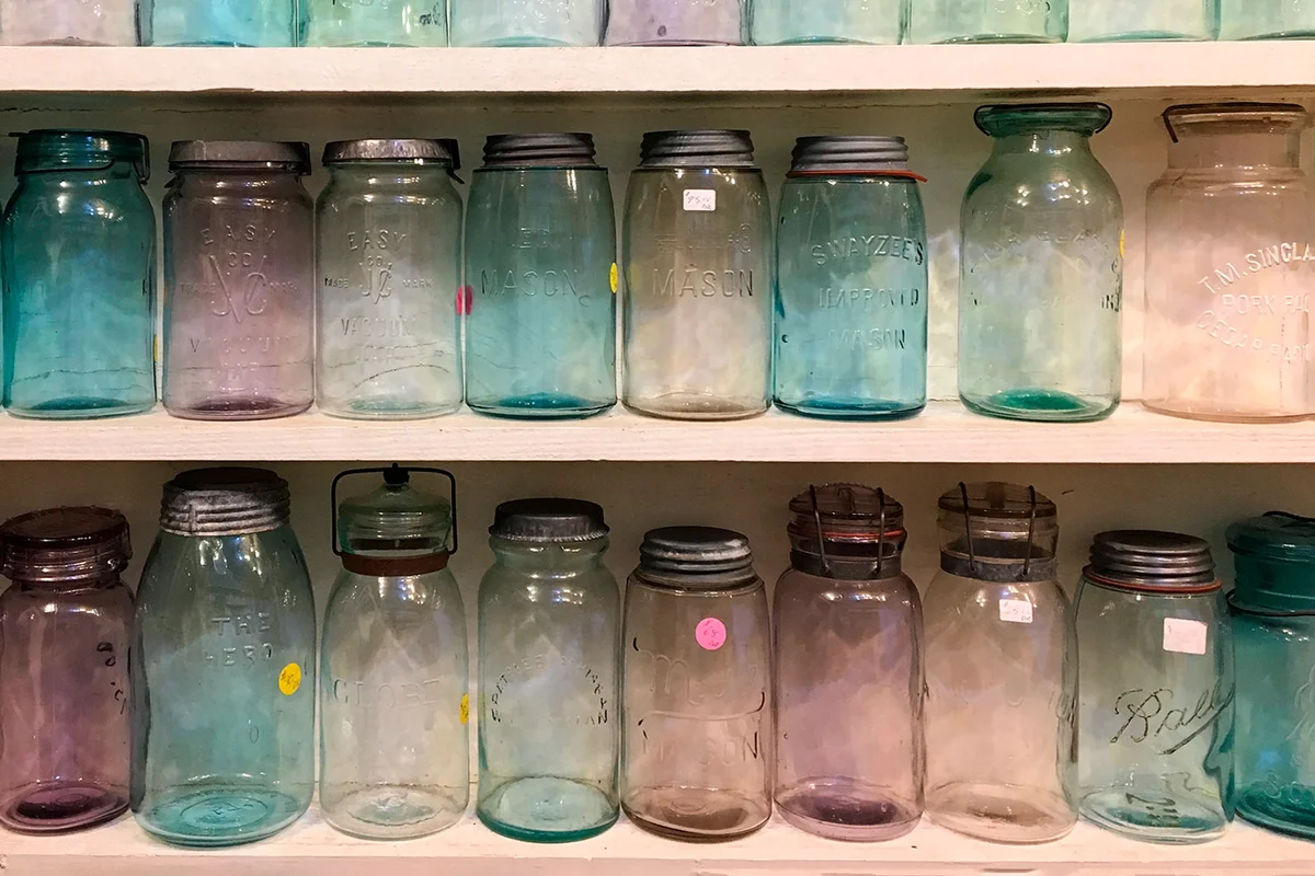 assorted antique canning jars on a shelf